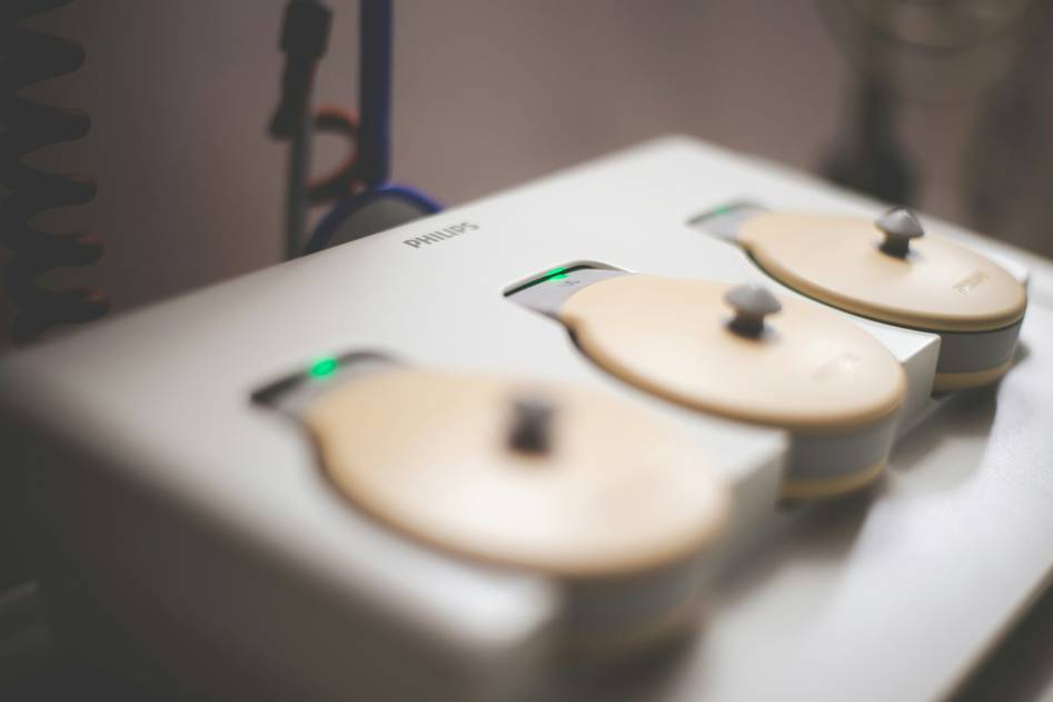 Founder of GlowTech testing an anti-aging facial device in a clean, minimalist studio