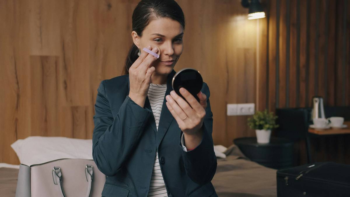 Woman using a smart anti-aging facial device that scans her face; some devices recognize your face to customize treatment zones.
