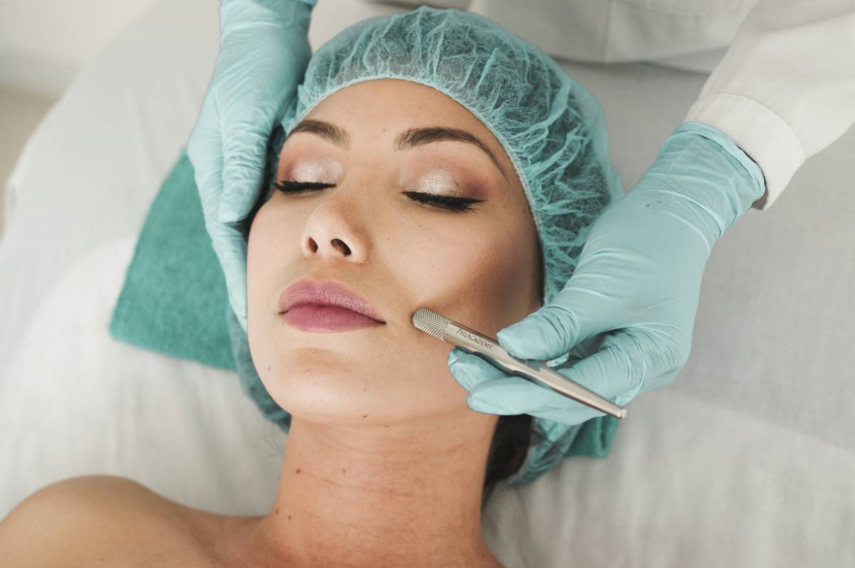 Woman using a handheld anti-aging facial device during a facial treatment to reduce facial wrinkles