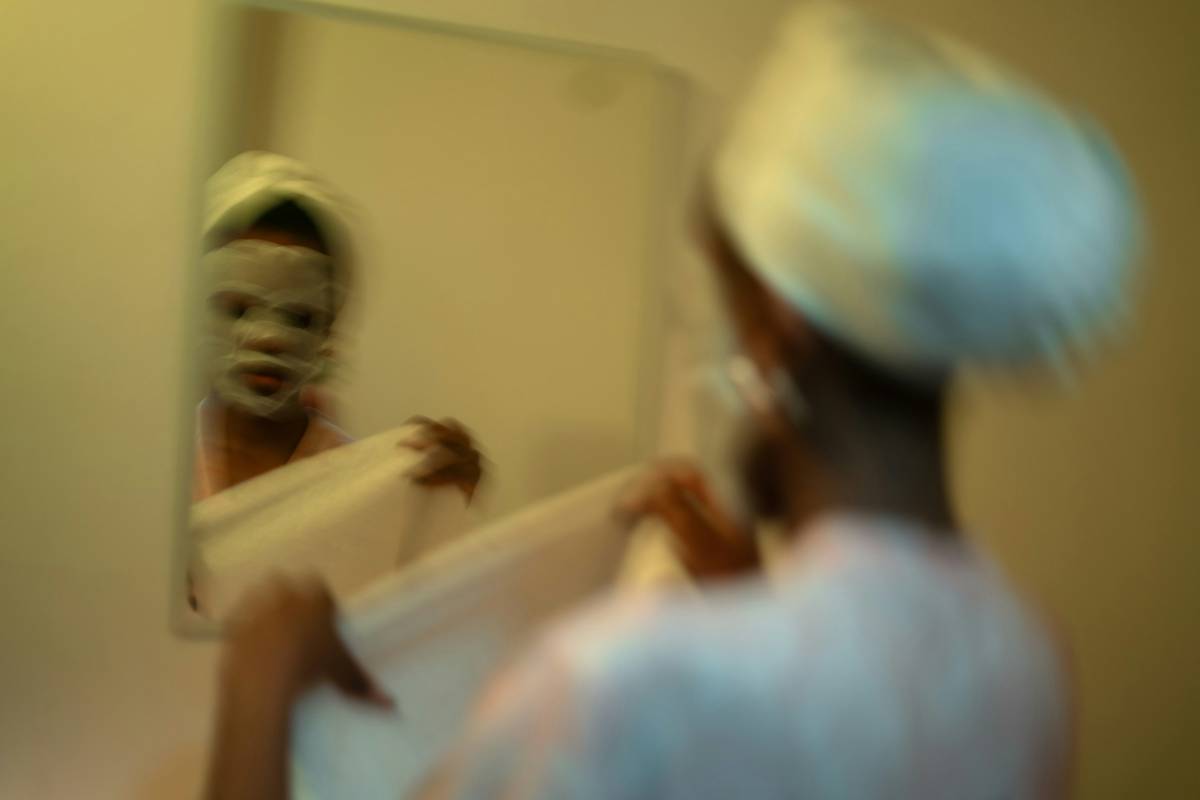 Woman using a meaningful beauty facial device on her cheek while seated at a vanity